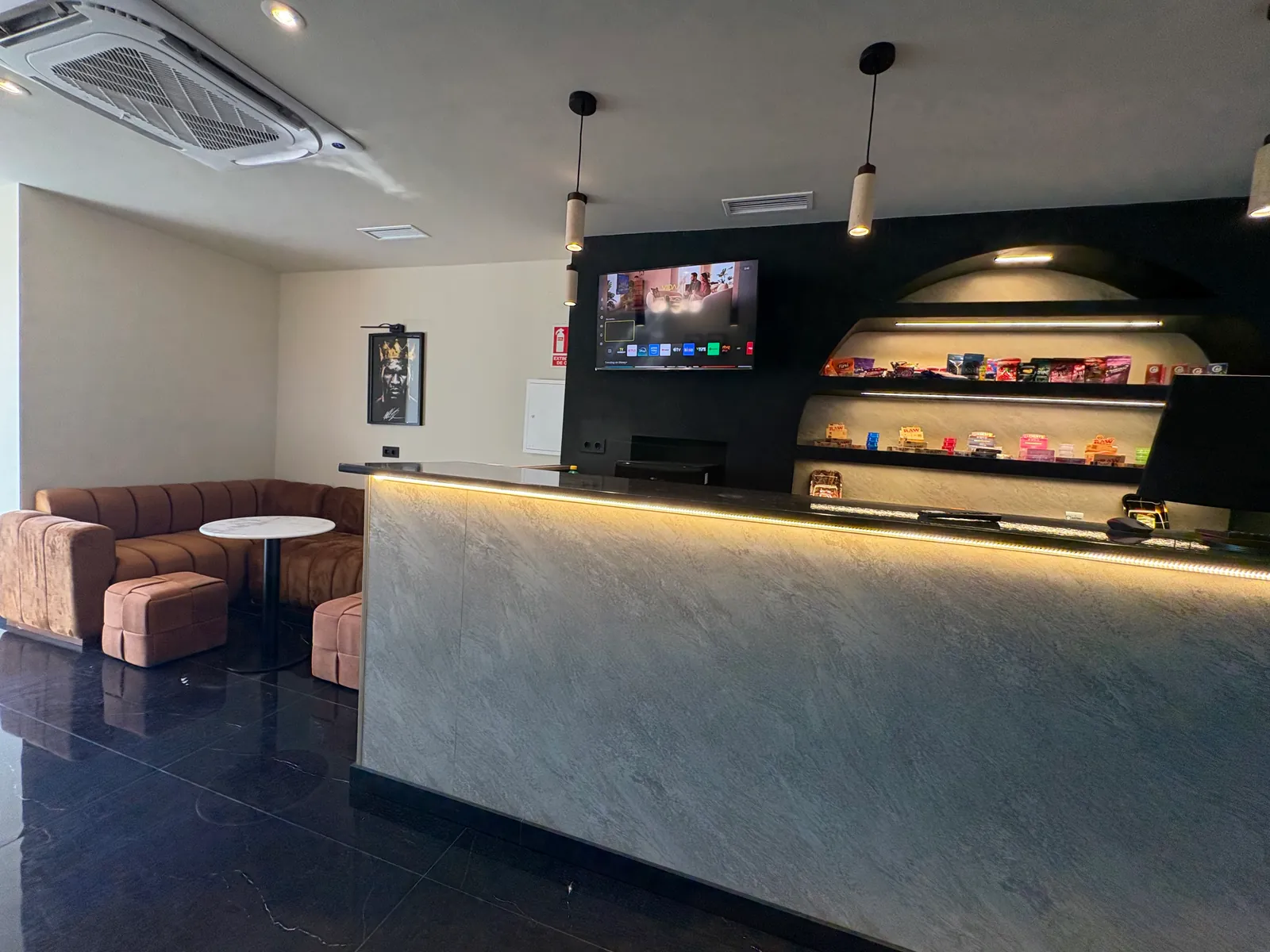 Un rincón con sofá y mesa de mármol junto a la recepción